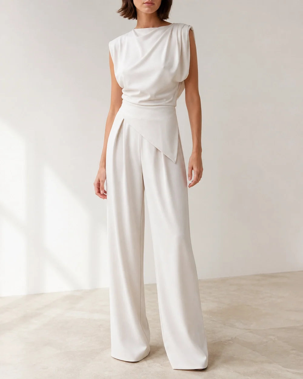 Women's white asymmetric draped top and wide-leg trousers set, product-first view.