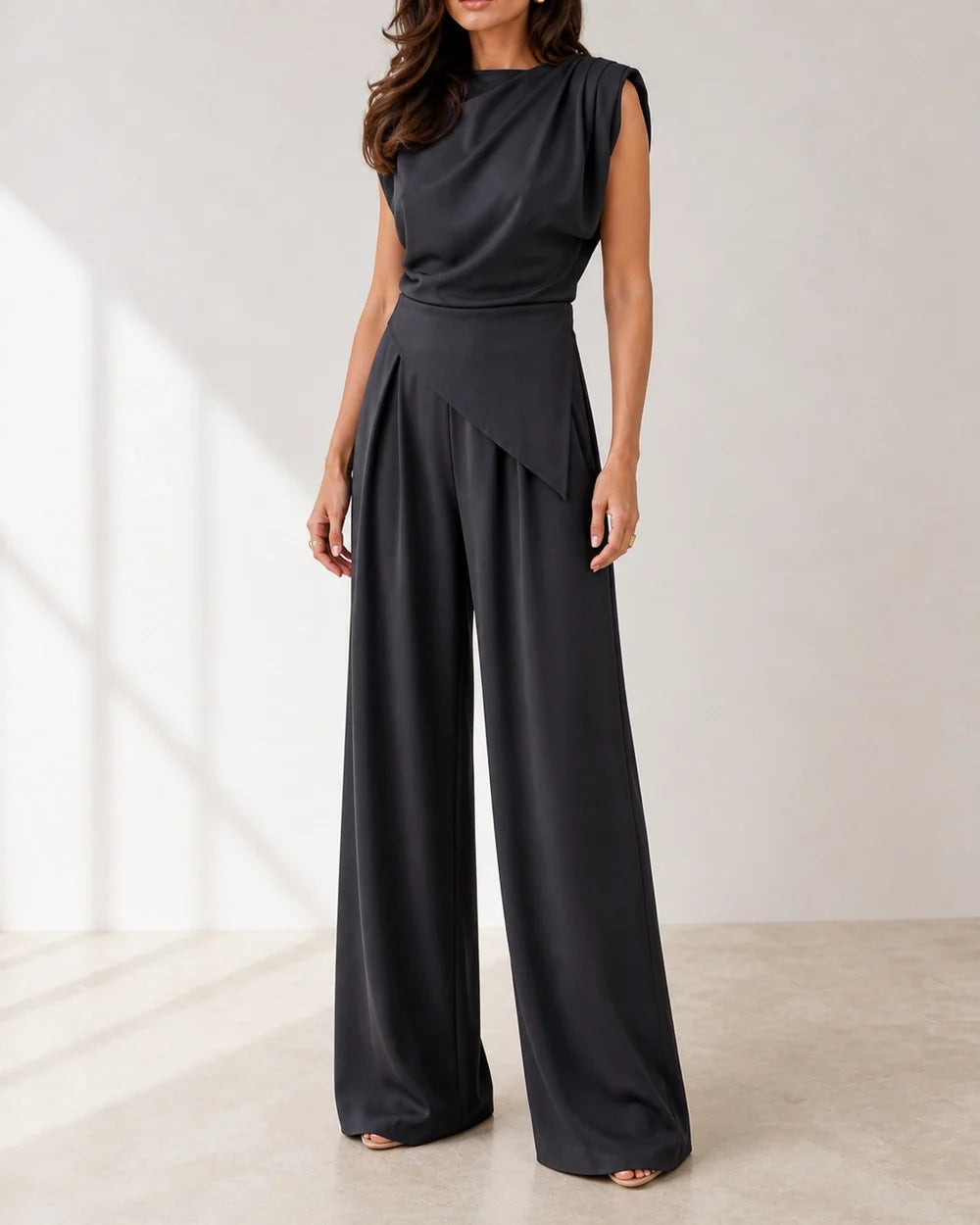 Women's black asymmetric draped top and wide-leg trousers set, product-first view.